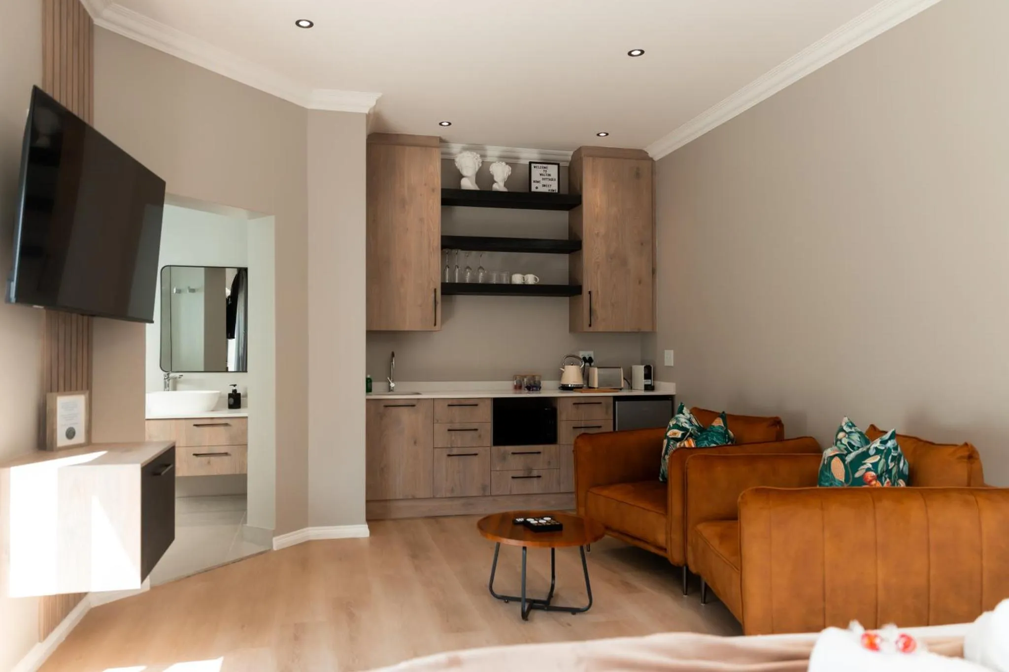 Espace de vie intérieur avec canapé, télévision et kitchenette.