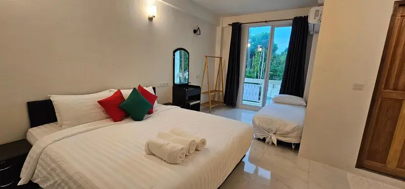 Une chambre lumineuse avec un grand lit et un lit simple.