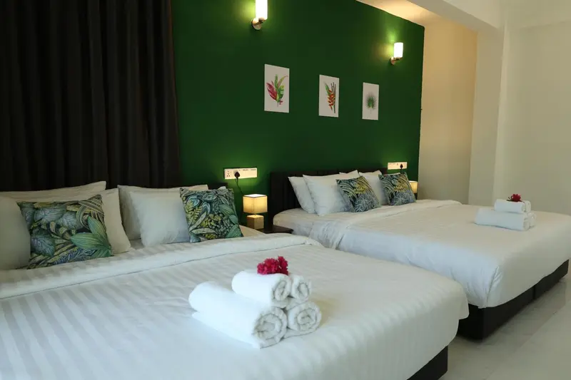 Une chambre lumineuse avec deux lits doubles décorés de coussins.