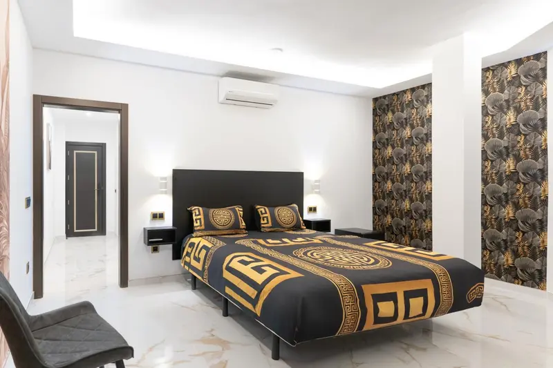 Une chambre moderne avec un grand lit recouvert d'une couette décorative.