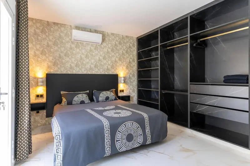 Une chambre moderne avec un grand lit et un placard intégré.