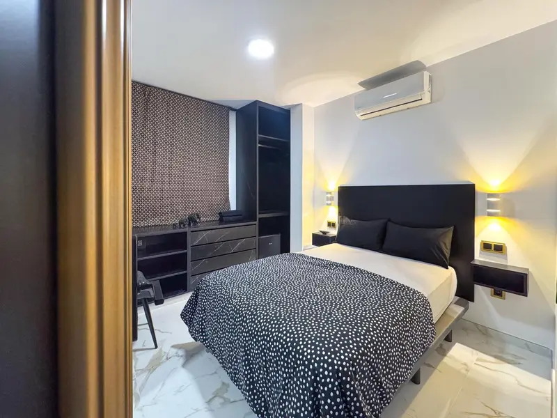 Une chambre moderne avec un grand lit et un bureau.
