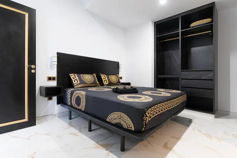 Une chambre moderne avec un grand lit et une décoration sobre.