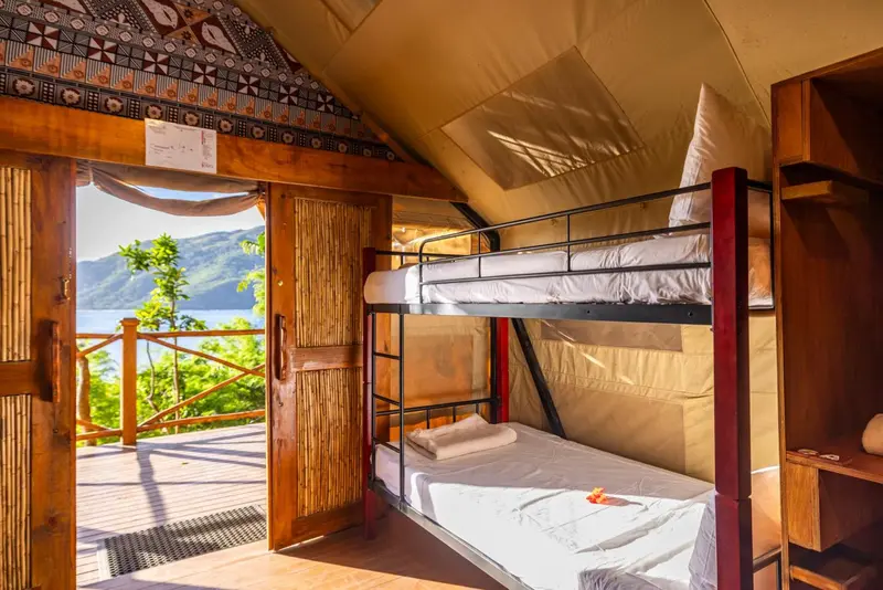 Une chambre avec lits superposés donnant sur une vue dégagée.