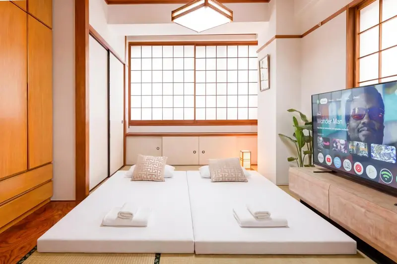 Une chambre avec deux lits jumeaux et une télévision à écran plat.