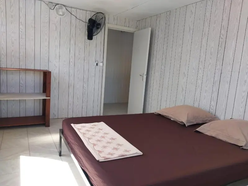 Une chambre simple avec un lit et une étagère.