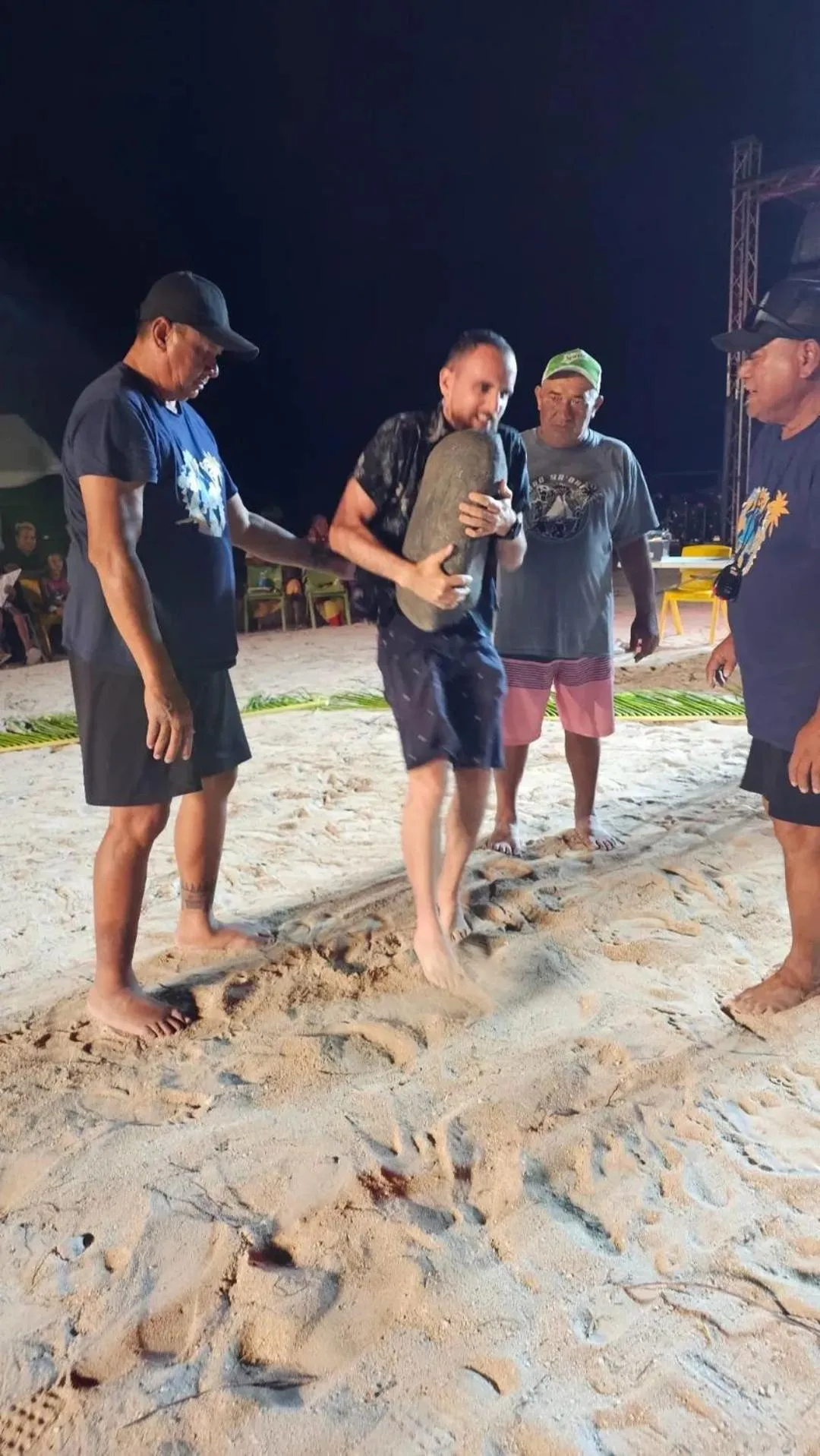 Des personnes se tiennent sur une plage de sable au crépuscule.