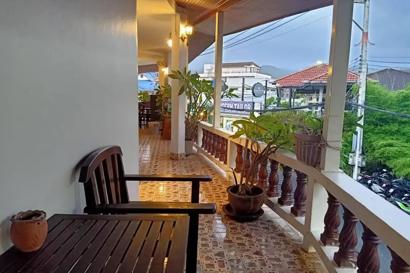 Terrasse couverte avec mobilier en bois et plantes.