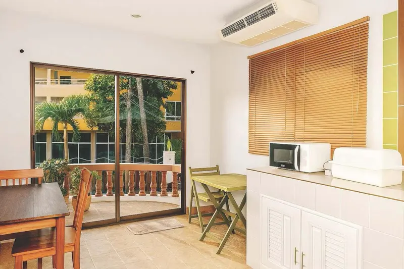 Une kitchenette lumineuse s'ouvre sur une terrasse avec vue sur la végétation.