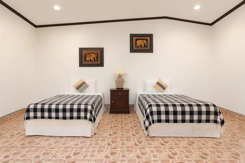 Une chambre lumineuse avec deux lits simples et une décoration sobre.