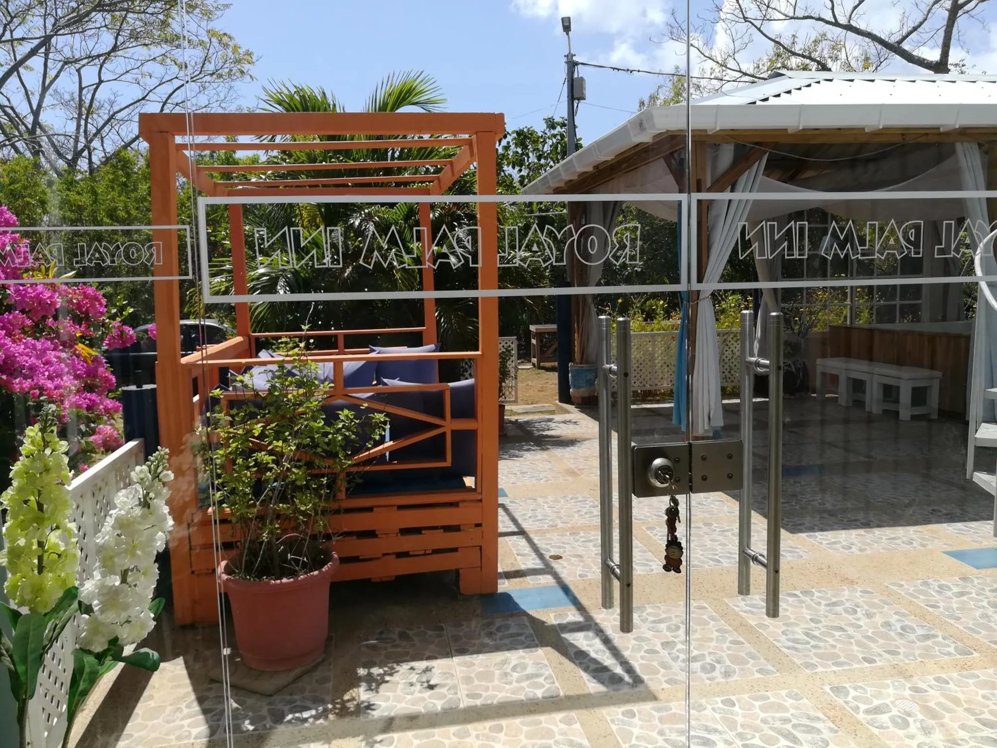 Espace de détente extérieur avec mobilier coloré et végétation tropicale.