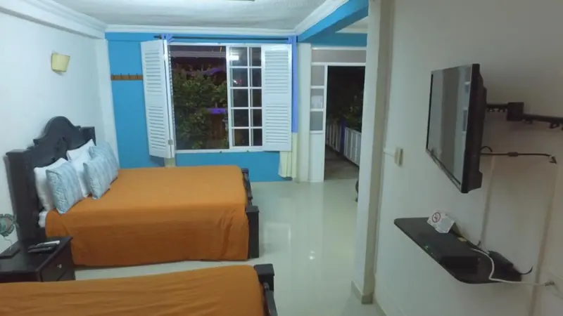 Une chambre lumineuse avec deux lits et une vue sur l'extérieur.