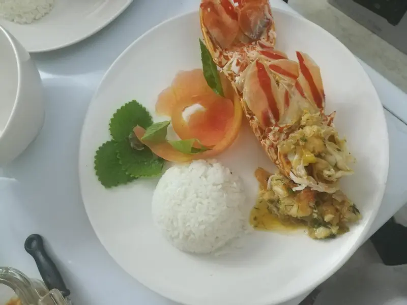 Assiette de homard grillé avec riz et garniture.