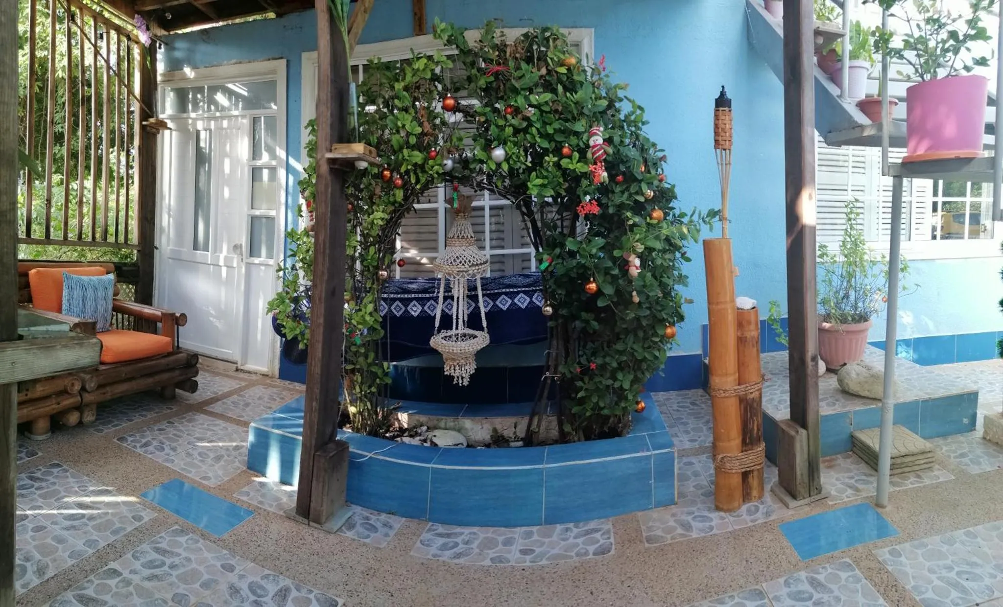Terrasse ombragée avec fontaine décorative et mobilier d'extérieur.