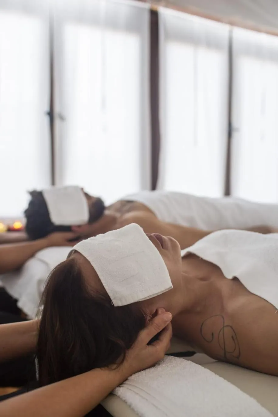 Des personnes allongées sur des tables de massage dans une pièce lumineuse.