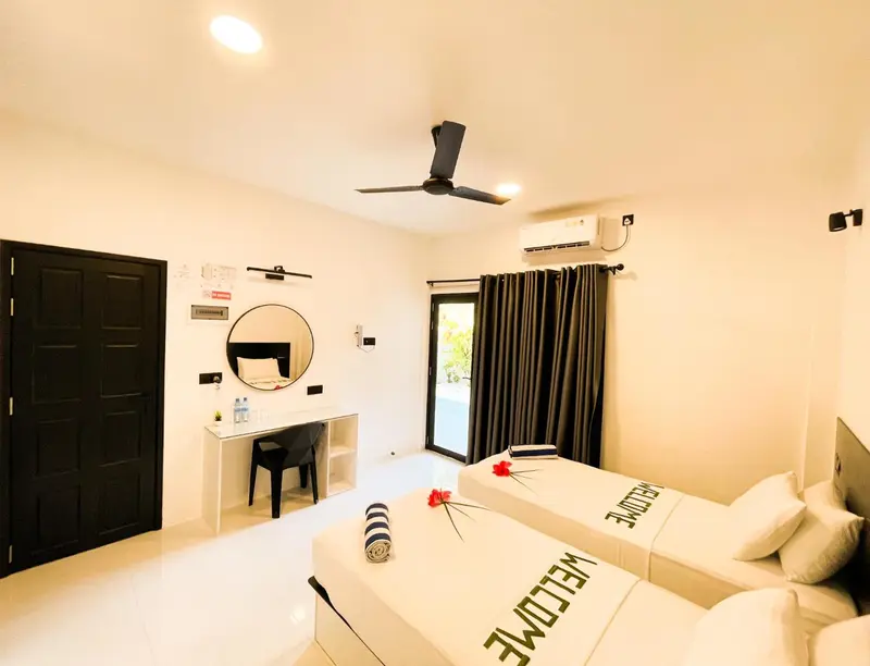 Une chambre lumineuse avec deux lits simples et un bureau.