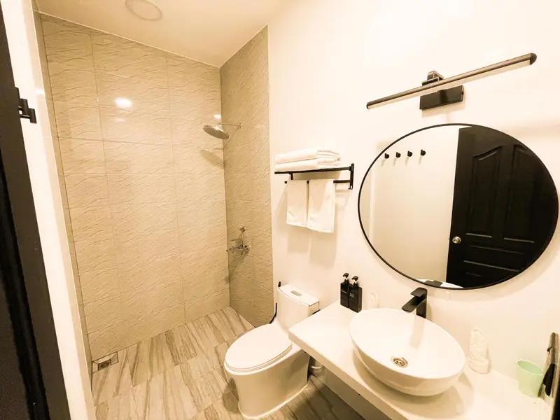 Une salle de bain moderne avec douche à l'italienne et grand miroir.