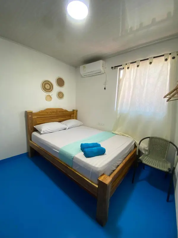 Une chambre lumineuse avec un lit double et une décoration murale.