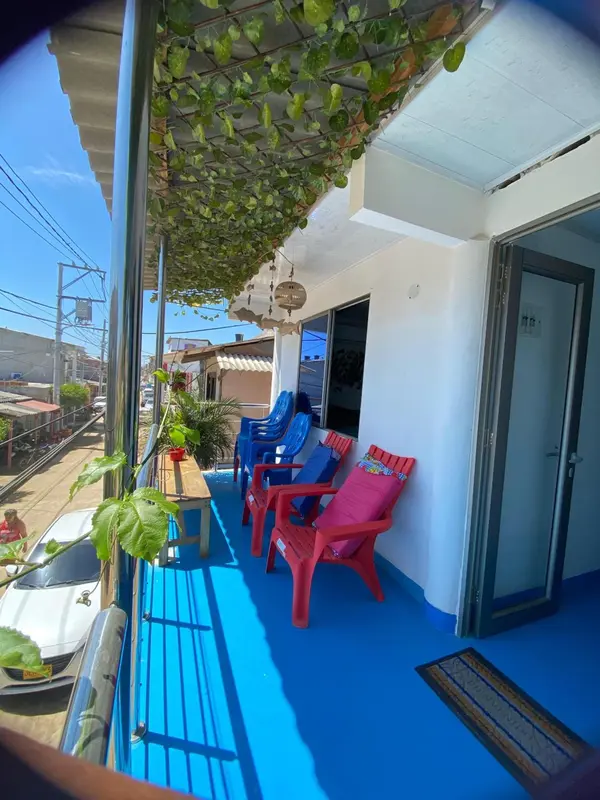 Terrasse colorée avec mobilier en plastique et végétation luxuriante.