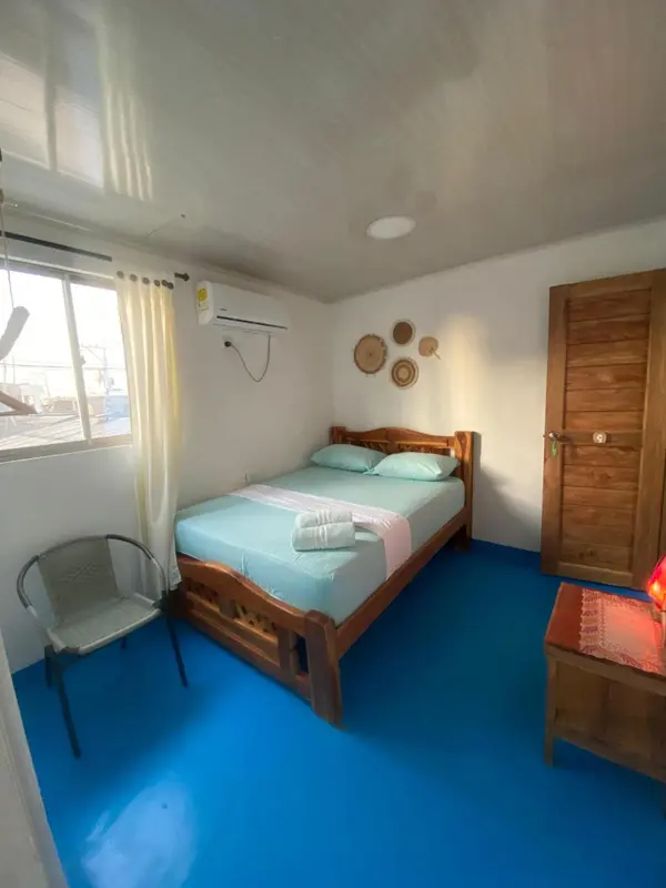Une chambre lumineuse avec un lit fait et une décoration murale.