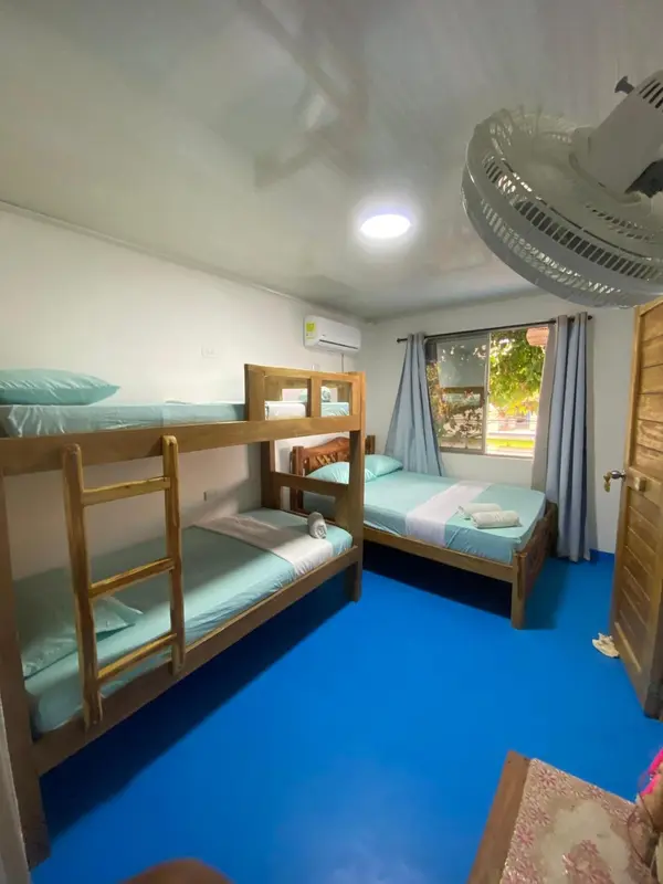 Une chambre avec des lits superposés et un lit simple.