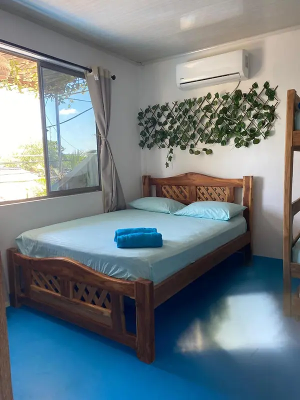 Une chambre lumineuse avec un lit en bois et un décor floral.