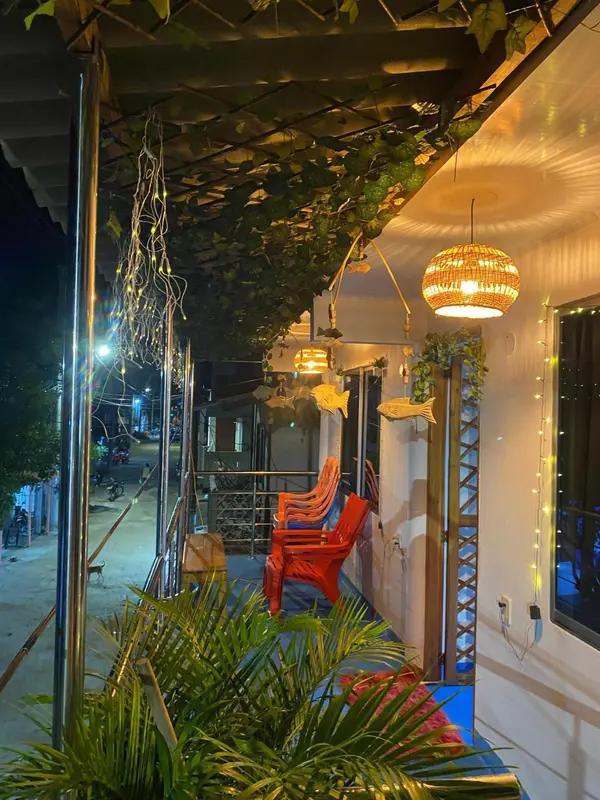 Terrasse ombragée avec mobilier d'extérieur et végétation tropicale.