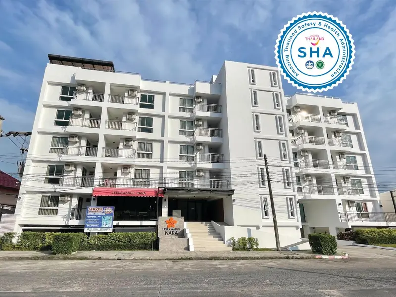 Façade d'un bâtiment blanc à plusieurs étages avec des balcons et une entrée.