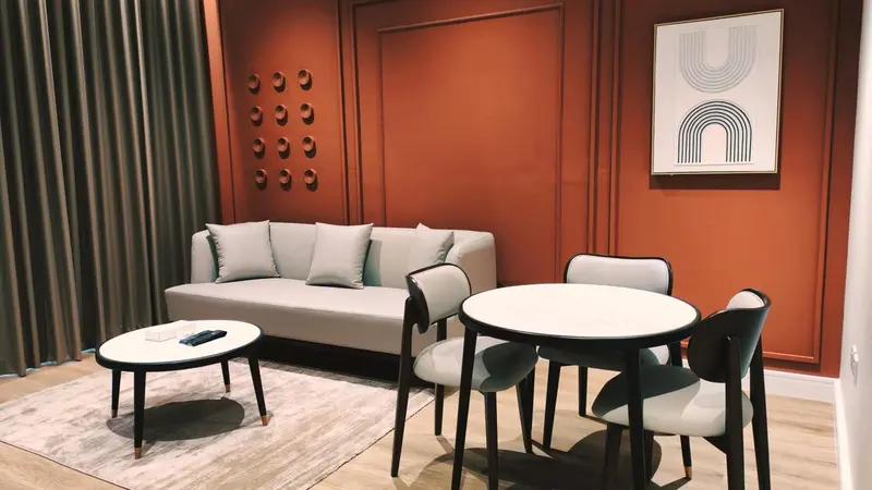 Un salon avec un canapé gris et une table à manger ronde.