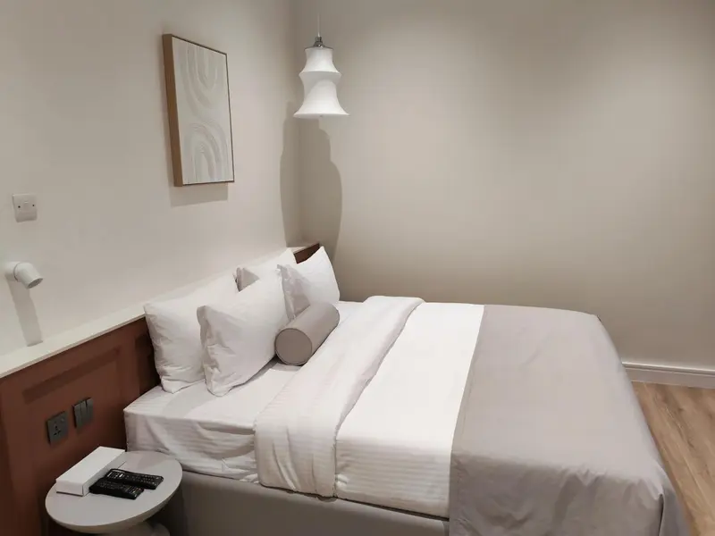 Une chambre lumineuse avec un lit fait et une décoration sobre.
