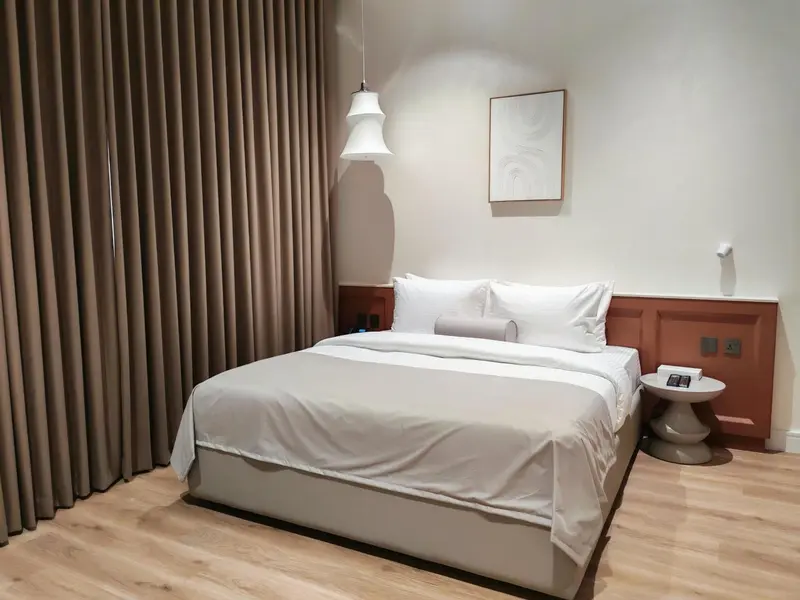 Une chambre lumineuse avec un grand lit recouvert de draps blancs.