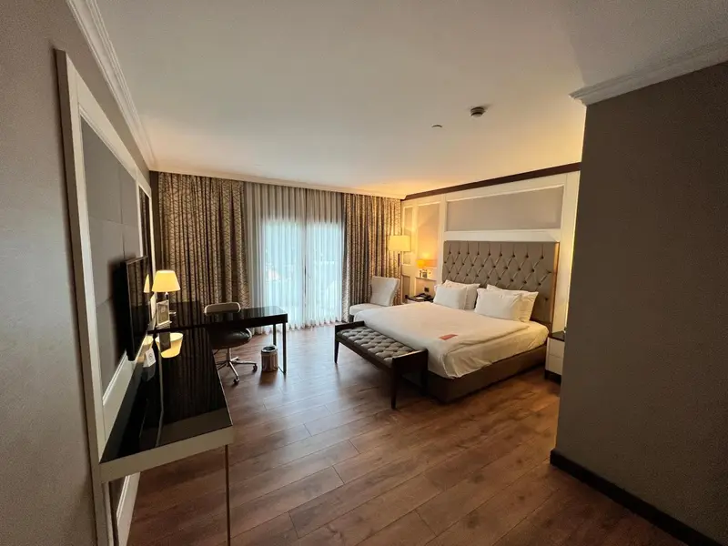 Une chambre spacieuse avec un grand lit et un bureau.