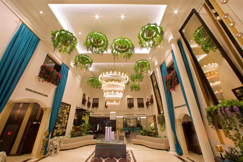 Vaste hall d'accueil avec une décoration florale suspendue et un éclairage lumineux.