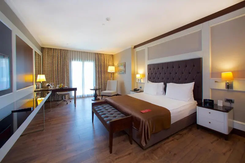 Une chambre d'hôtel lumineuse avec un grand lit et un bureau.