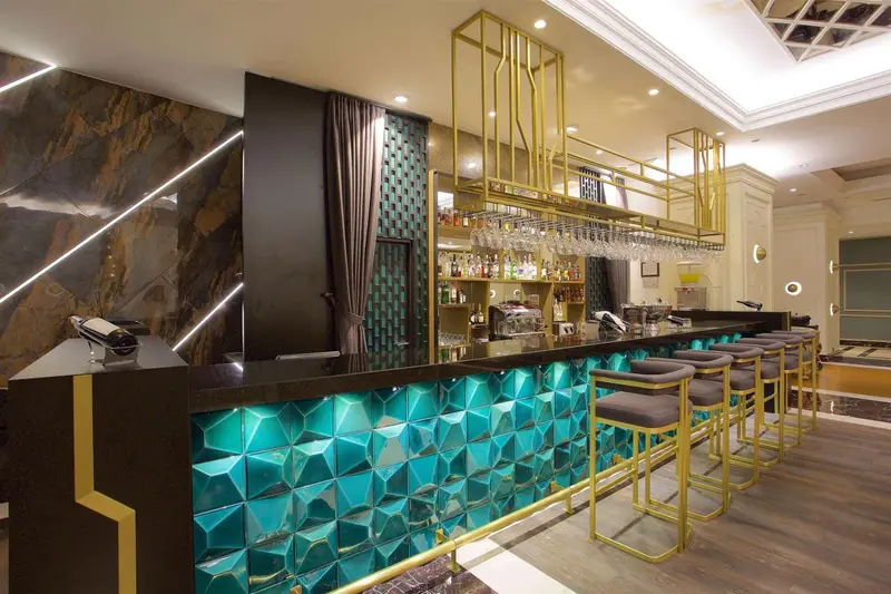 Un comptoir de bar moderne avec des tabourets et une décoration lumineuse.