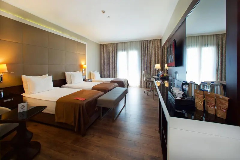Chambre d'hôtel moderne avec deux lits et une décoration sobre.