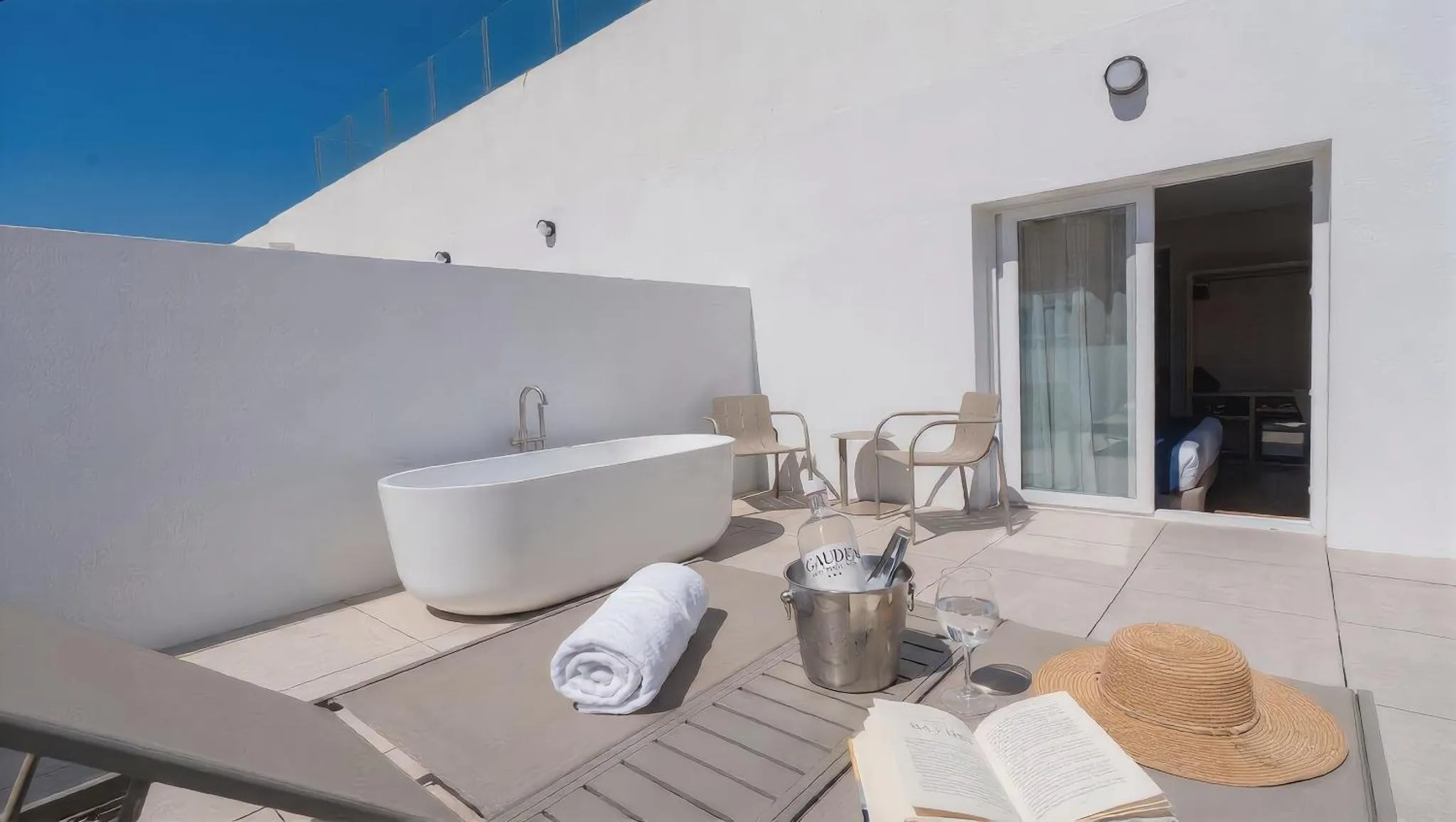 Terrasse avec baignoire et mobilier de détente.
