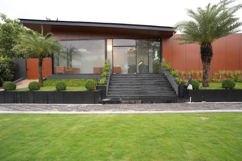 Façade d'un bâtiment moderne avec un escalier menant à une entrée vitrée.