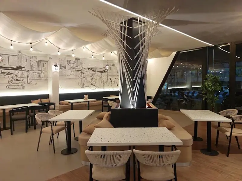 Une salle lumineuse avec des tables et des banquettes confortables.
