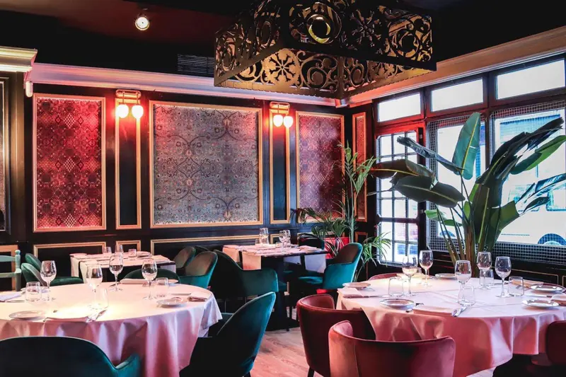Une salle de restaurant élégante avec des tables dressées et une décoration raffinée.