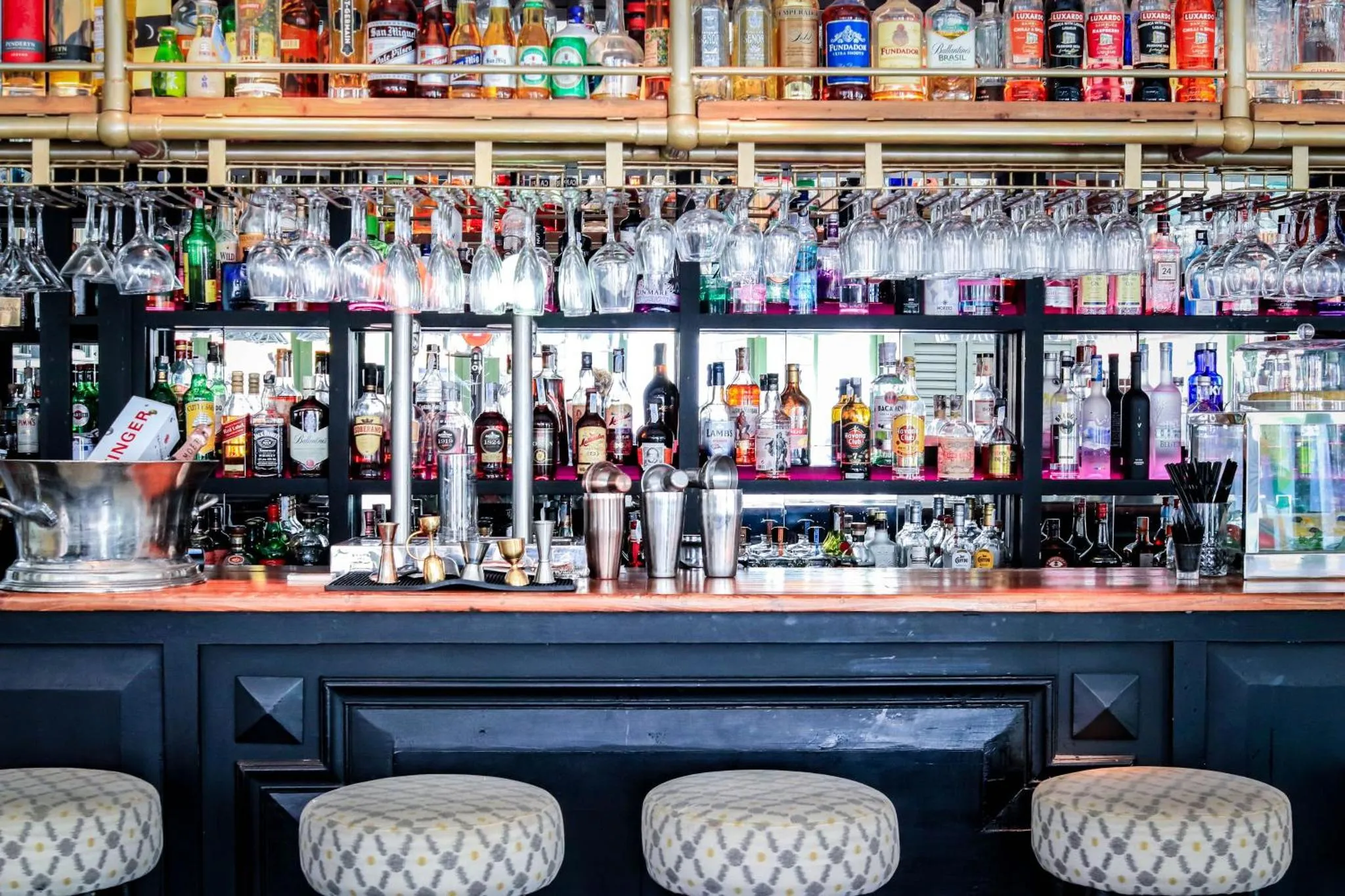 Un comptoir de bar bien garni avec une variété de bouteilles et de verres.
