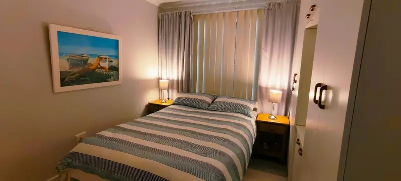 Une chambre lumineuse avec un lit double et une décoration sobre.