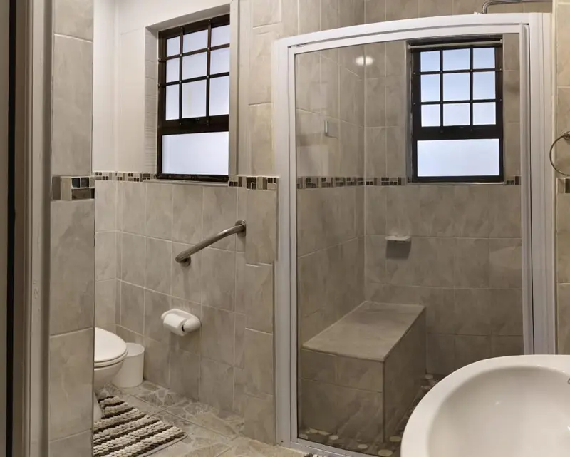 Une salle de bain carreee avec douche a l'italienne et toilettes.