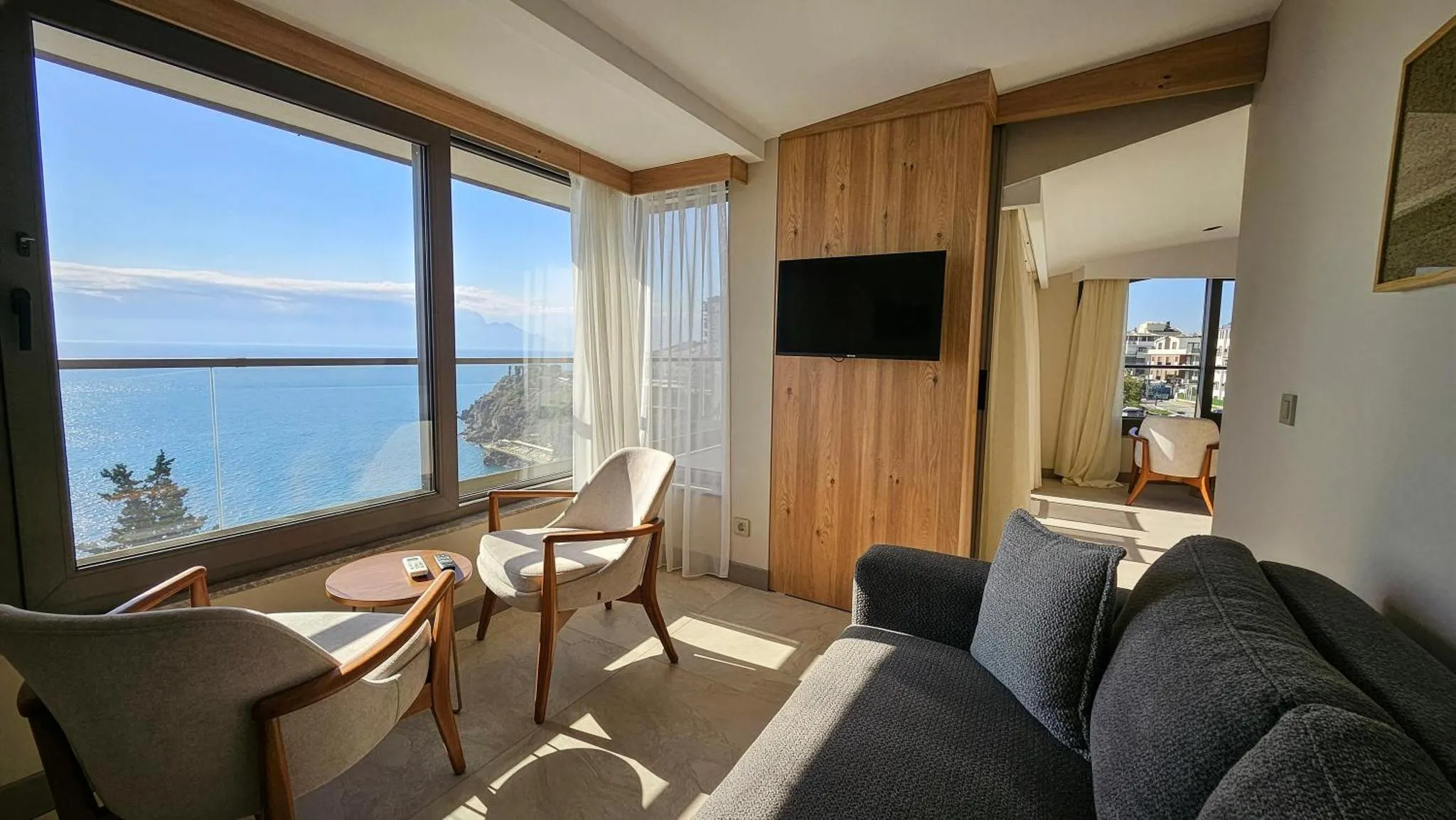 Un salon lumineux avec vue sur la mer depuis de grandes baies vitrées.