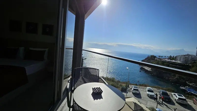 Une terrasse avec table ronde offre une vue dégagée sur la mer scintillante.
