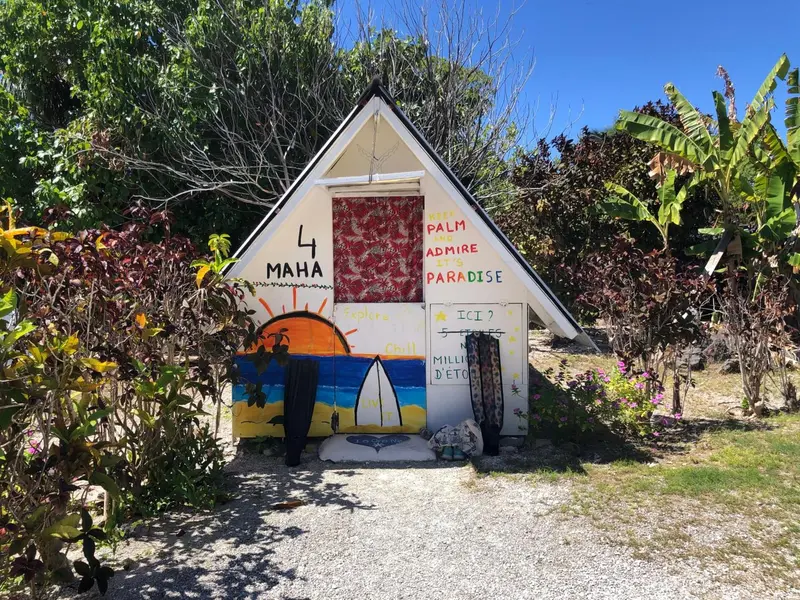 Petite maison peinte avec des motifs marins et un jardin tropical.