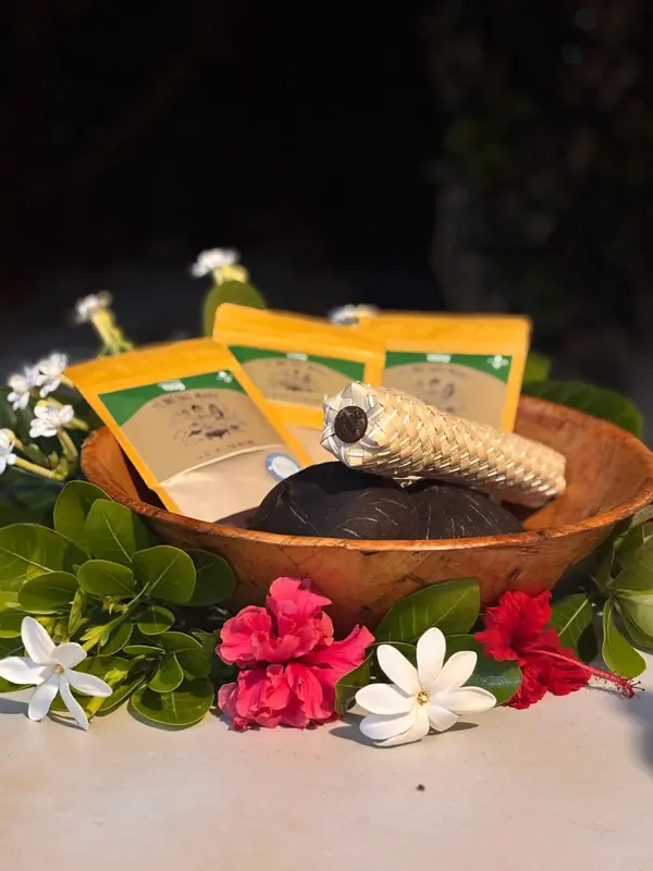 Présentation de produits dans un bol en bois décoré de fleurs et de feuilles.