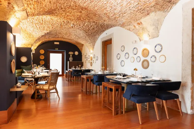 Une salle à manger lumineuse avec des tables dressées et un décor mural original.
