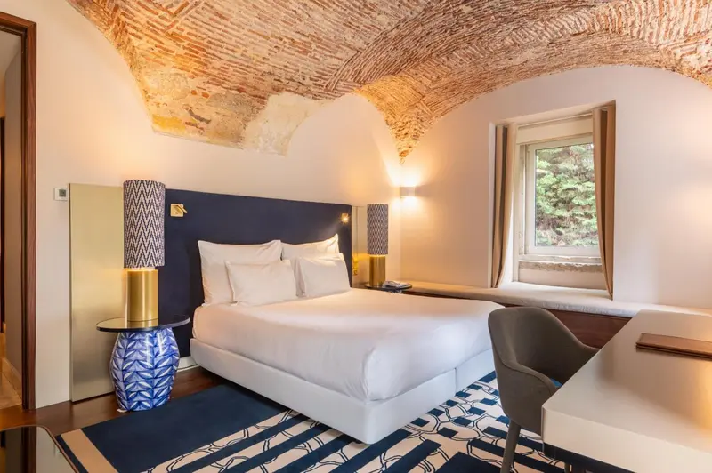 Une chambre à coucher lumineuse avec un grand lit et une fenêtre.