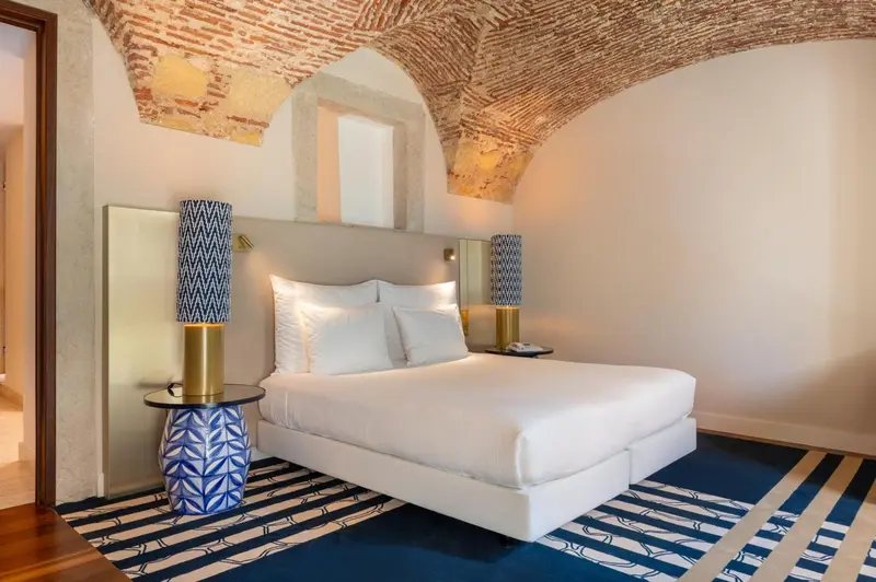 Une chambre lumineuse avec un grand lit et une décoration soignée.